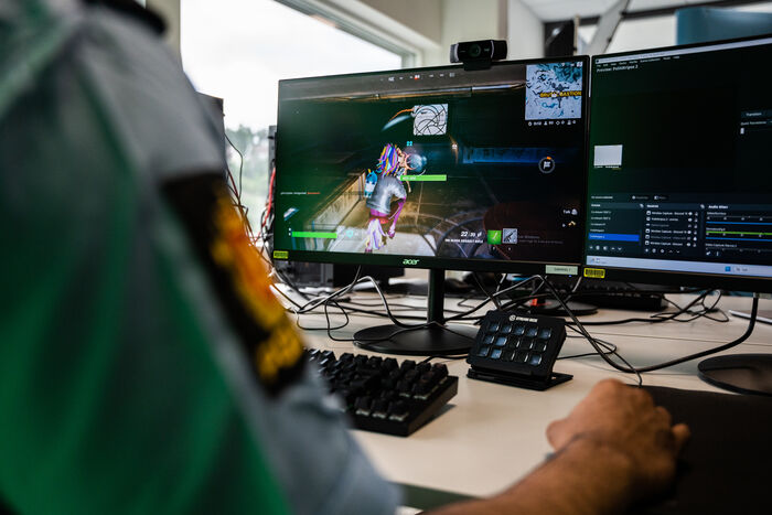 Bildet viser armene til en uniformert politimann. Han skriver på et tastatur.
