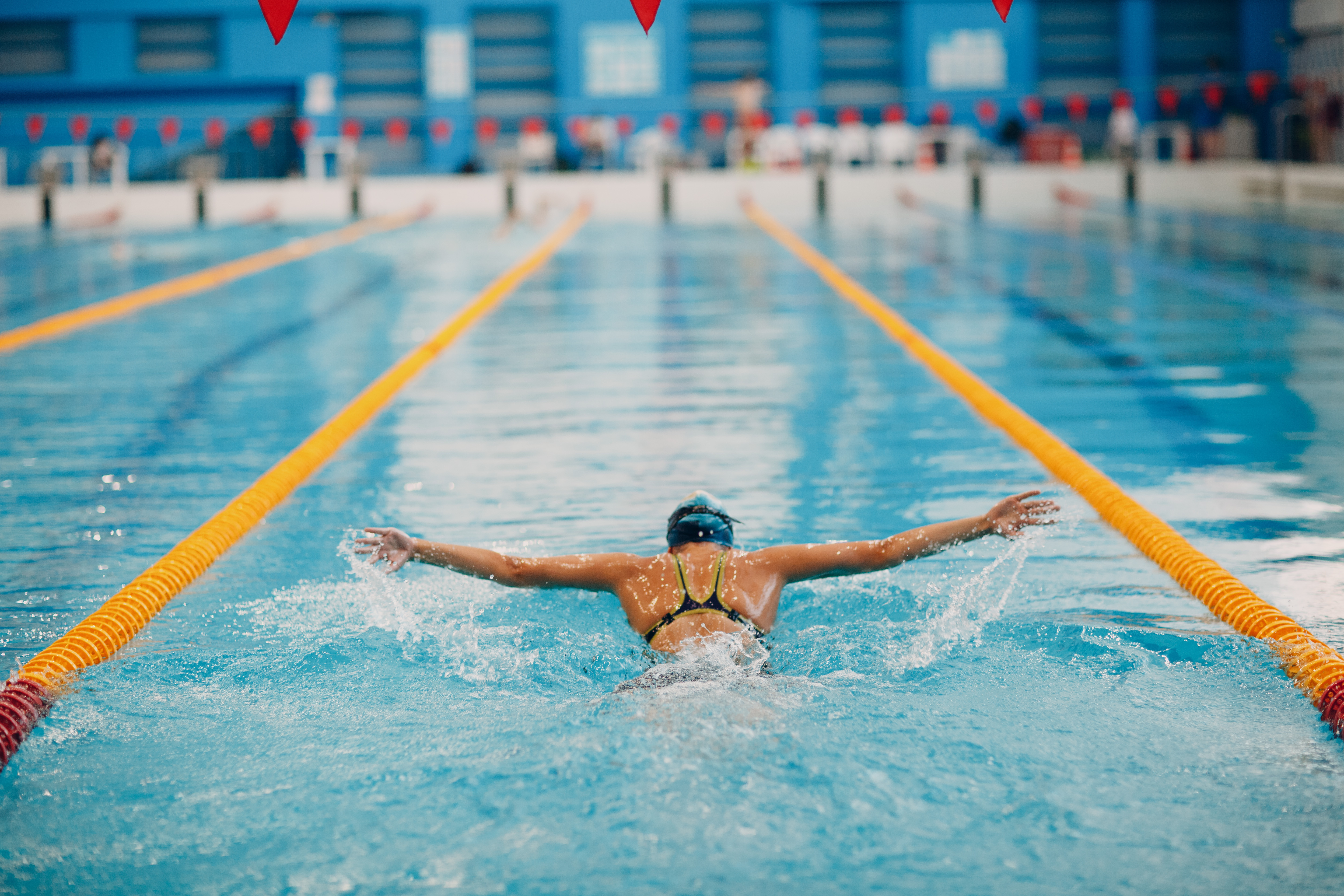 En kvinne svømmer i et innendørs basseng