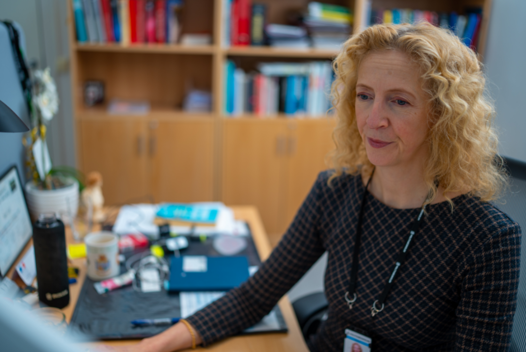 Inger Coll sitter på kontoret sitt og jobber 
