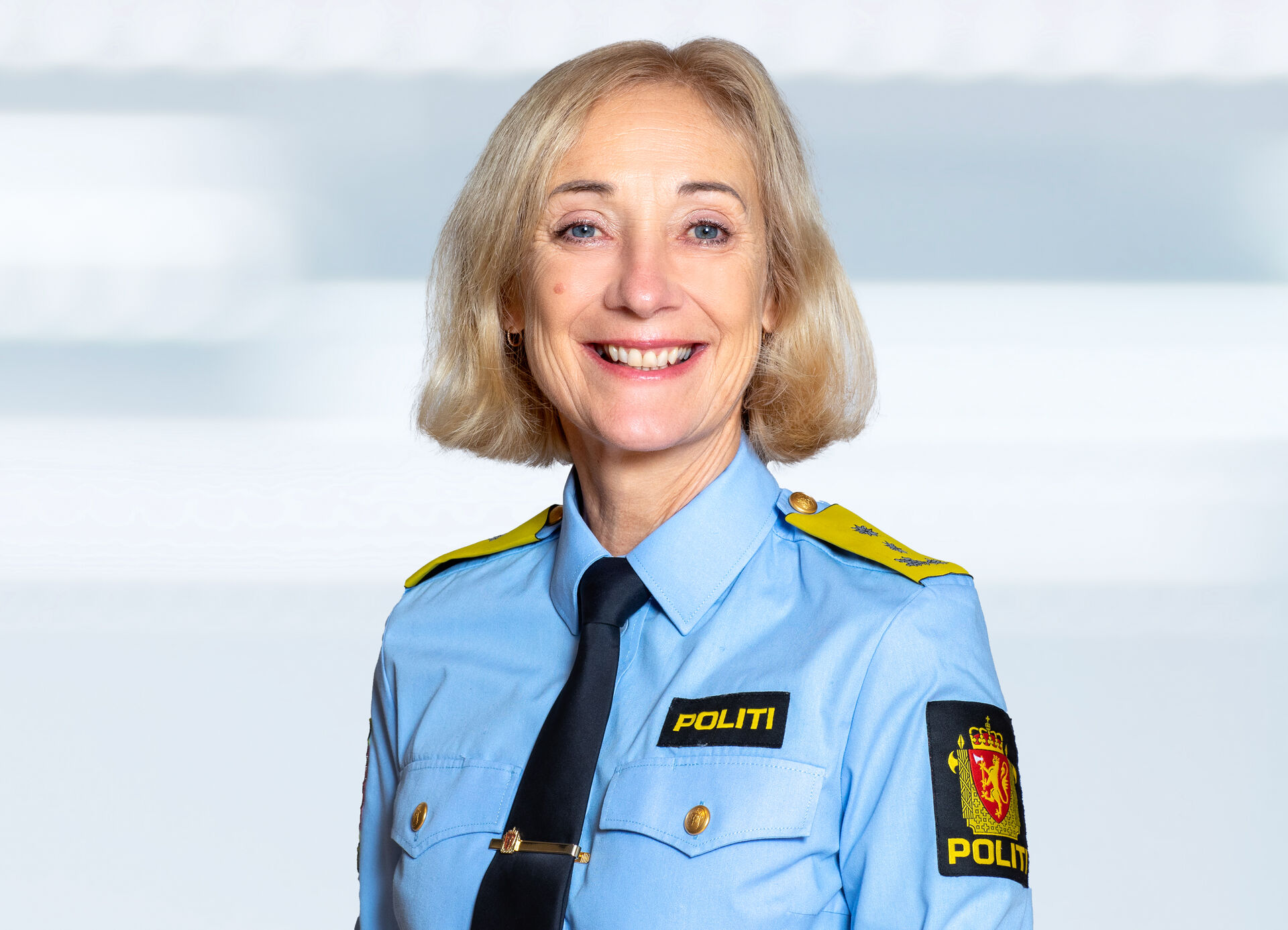 Bilde av rektor, en blond dame i blå politiuniform. Hun smiler.