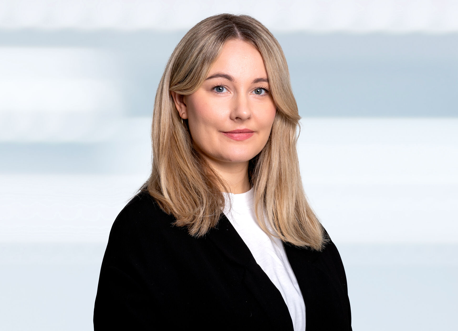 Portrett av kvinne iført svart jakke. Hun har blondt hår og ser rett inn i kamera.