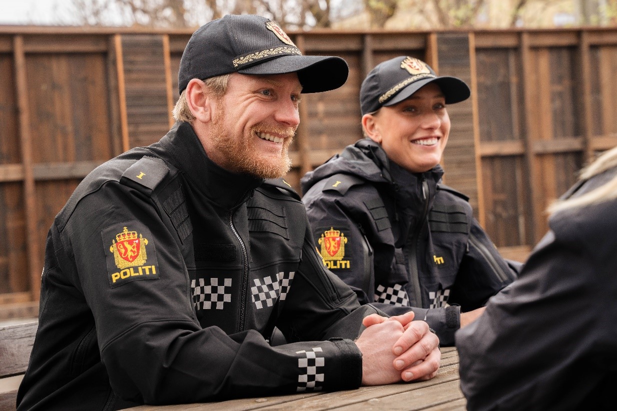   Police students sit outside at picnic tables