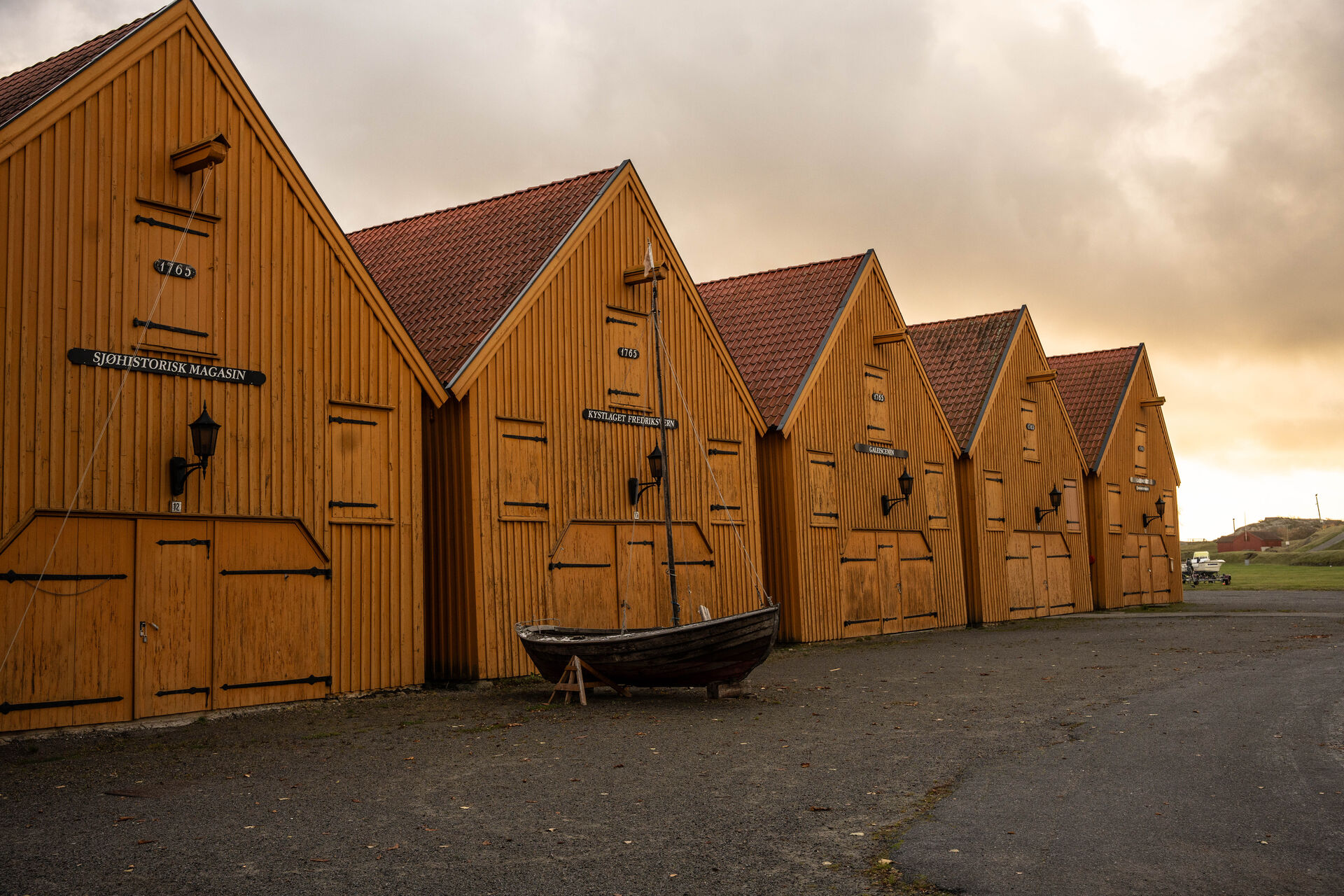 Four yellow harbor buildings with pointed roofs