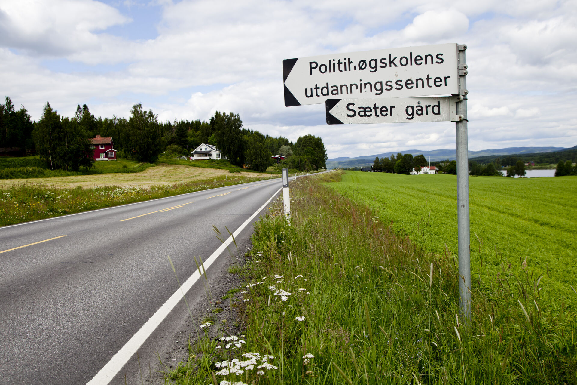 A sign by a field pointng to campus Kongsvinger