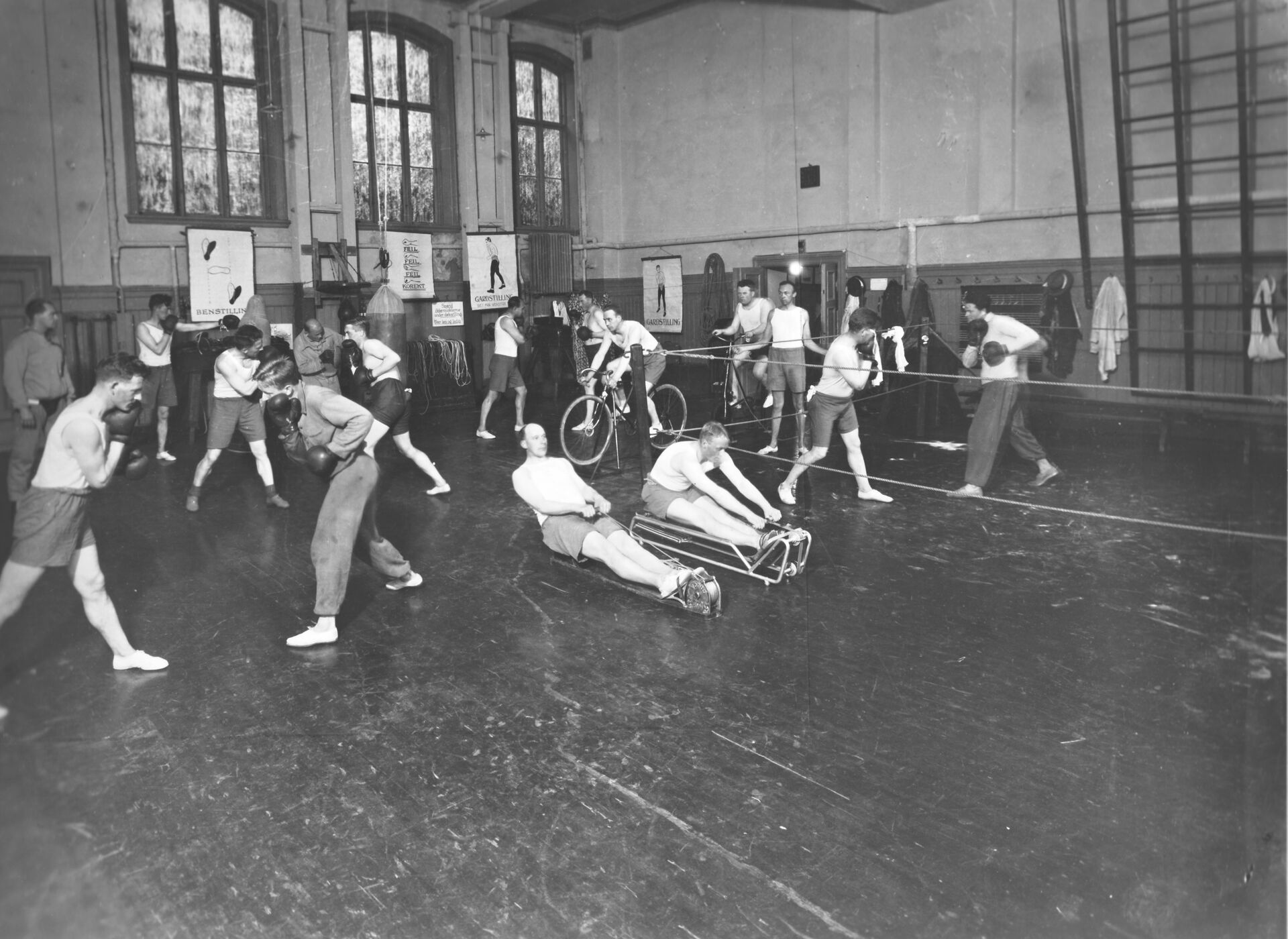 Gammel bilde som viser boksing og styrkeøvelser i gymsalen.