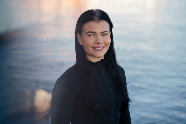 Anne-Lise stands and smiles to the camera