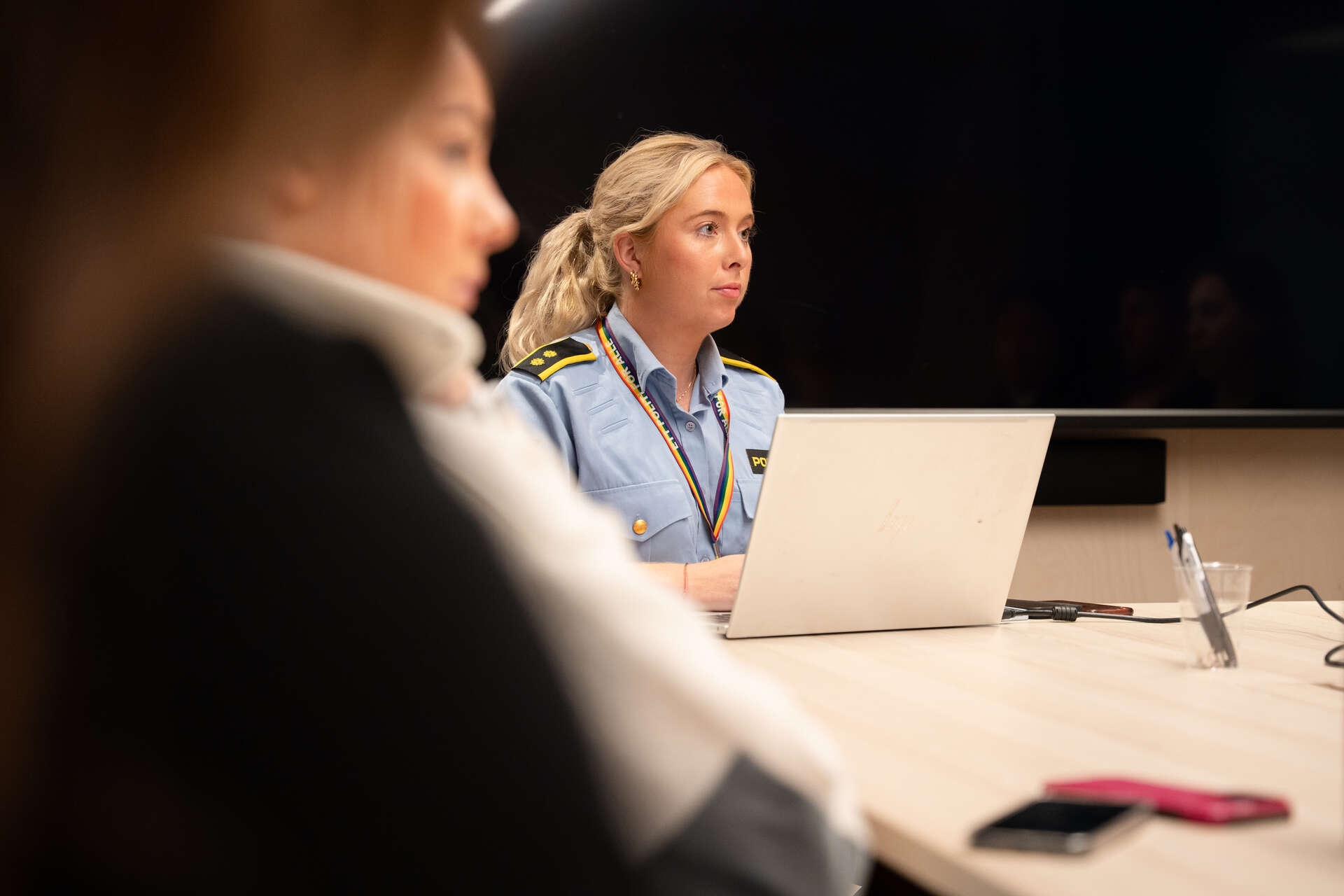 Politikvinne i et møte sitter bak PC-skjerm