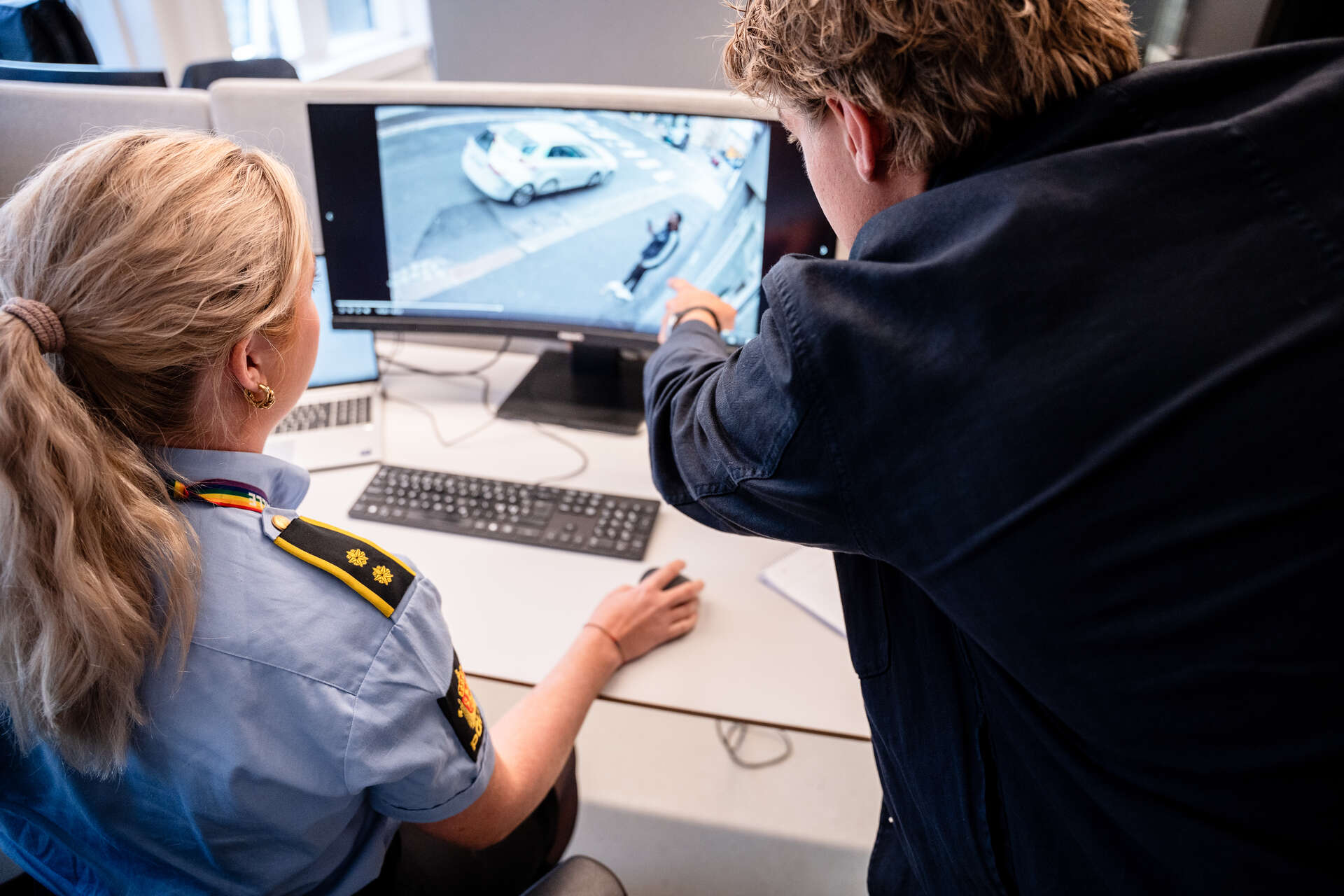To personer ser på en overvåkningsvideo 