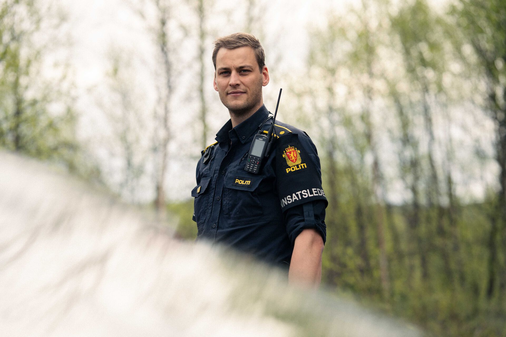 Politimann i uniform ser rett inn i kamera