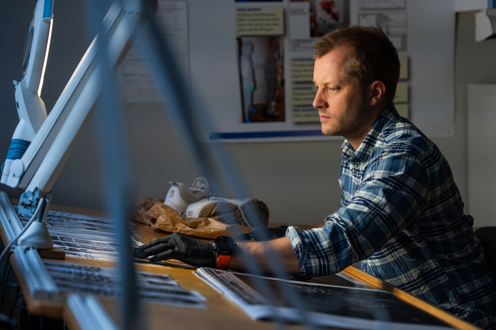 Mads sits at the desk and examines some shoes