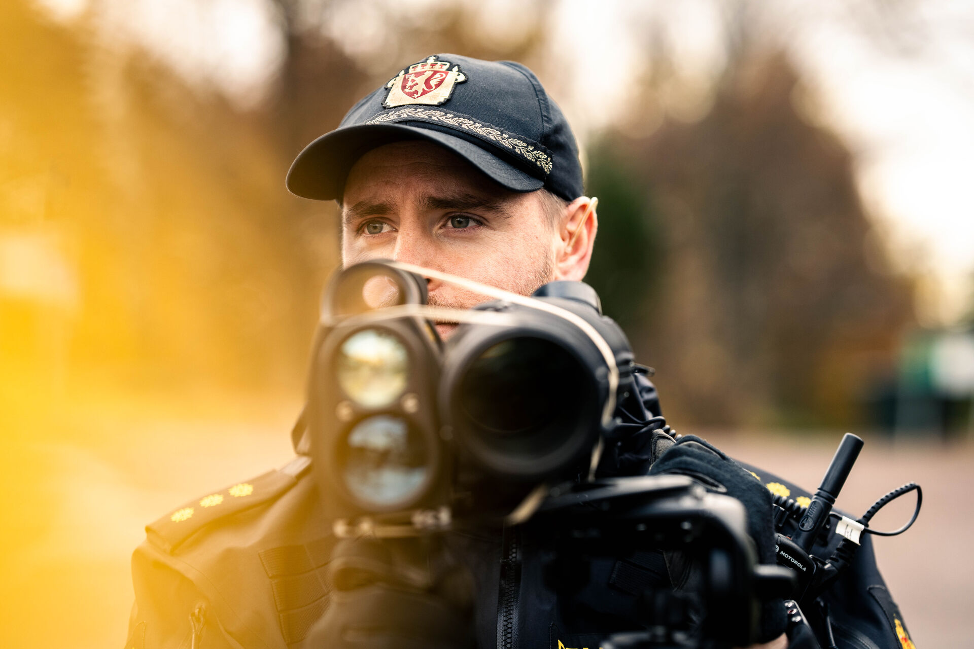 Hans is looking at the cars rushing past on the highway. He is standing with a speed measurer. 